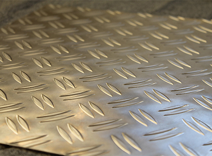 Gros plan d’une tôle aluminium striée avec des reliefs allongés disposés en alternance